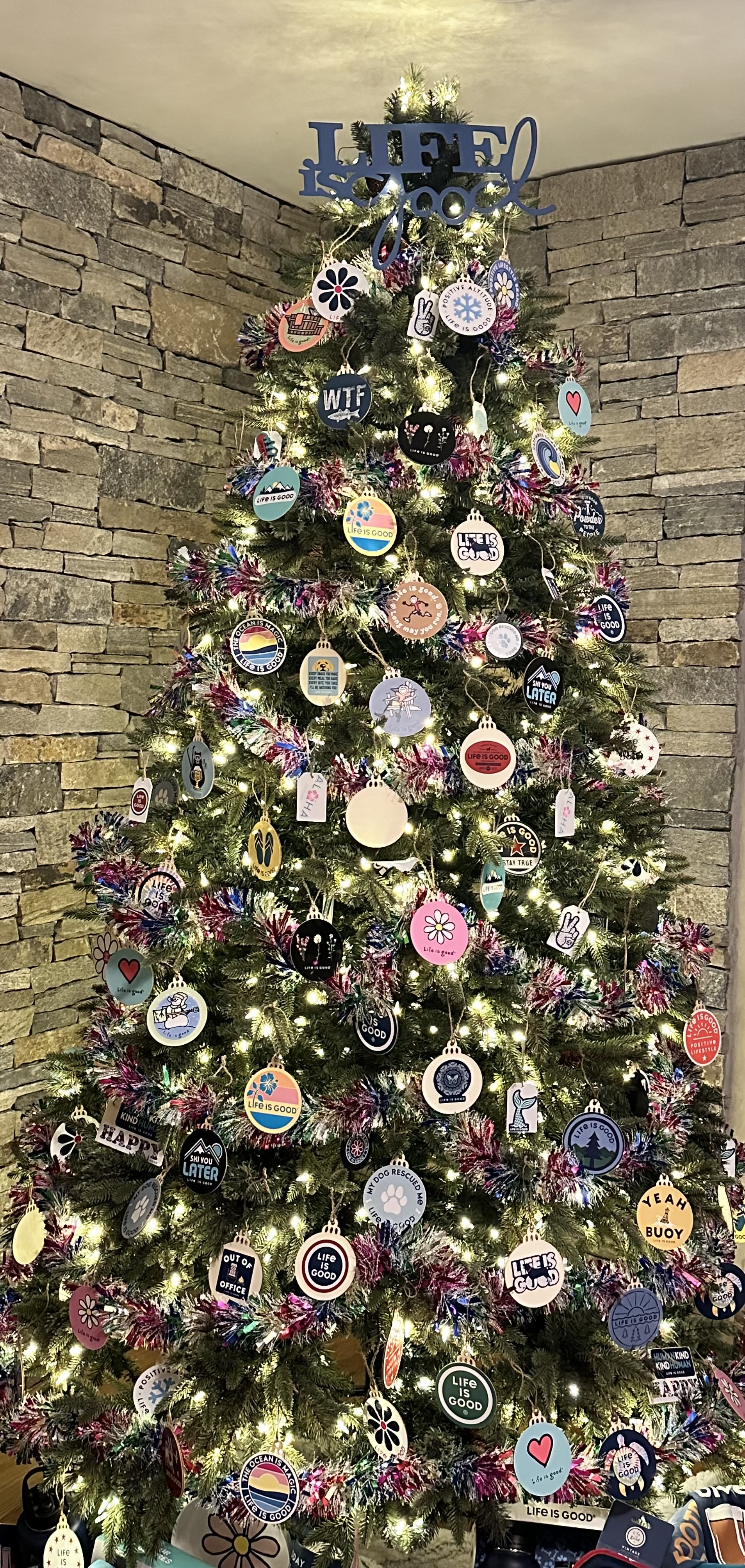 A brightly lit Life Is Good themed tree displayed at the Festival of Giving Trees